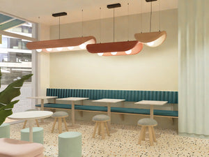 BuzziChip Upholstered Acoustic Ceiling Light with Pouf and Indoor Plant in Cafe Setting