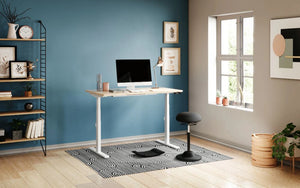 Leap Sit Stand Desk with Black Movement Stool and Black Against the Wall Shelving Unit in Home Office Setting