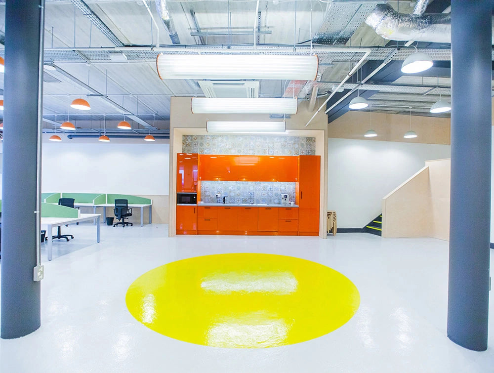 Open Area With Orange Kitchenette And Yellow Circle On Floor