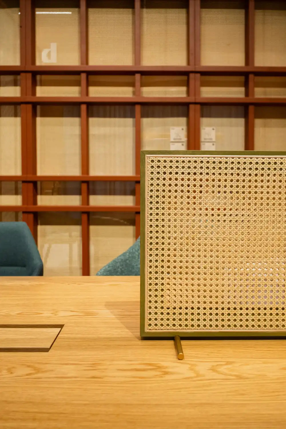 Solo T Rattan Desk Screen with Meeting Table in Modern Office Setting