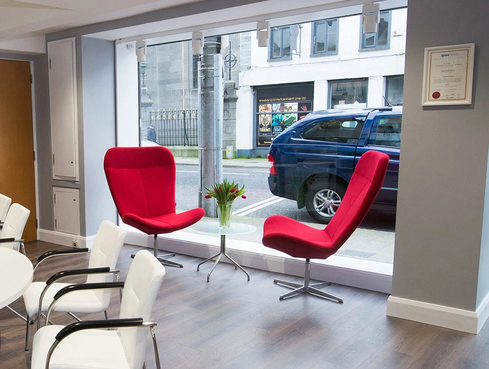 Two Red Chairs And Several White Chairs In Front Of Window