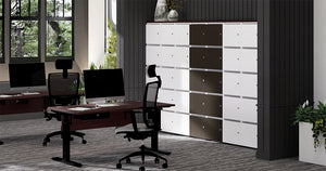 Uno Locker In Two Toned Finish With High Back Armchair And Dark Wooden Sit Stand Desk In Executive Setting