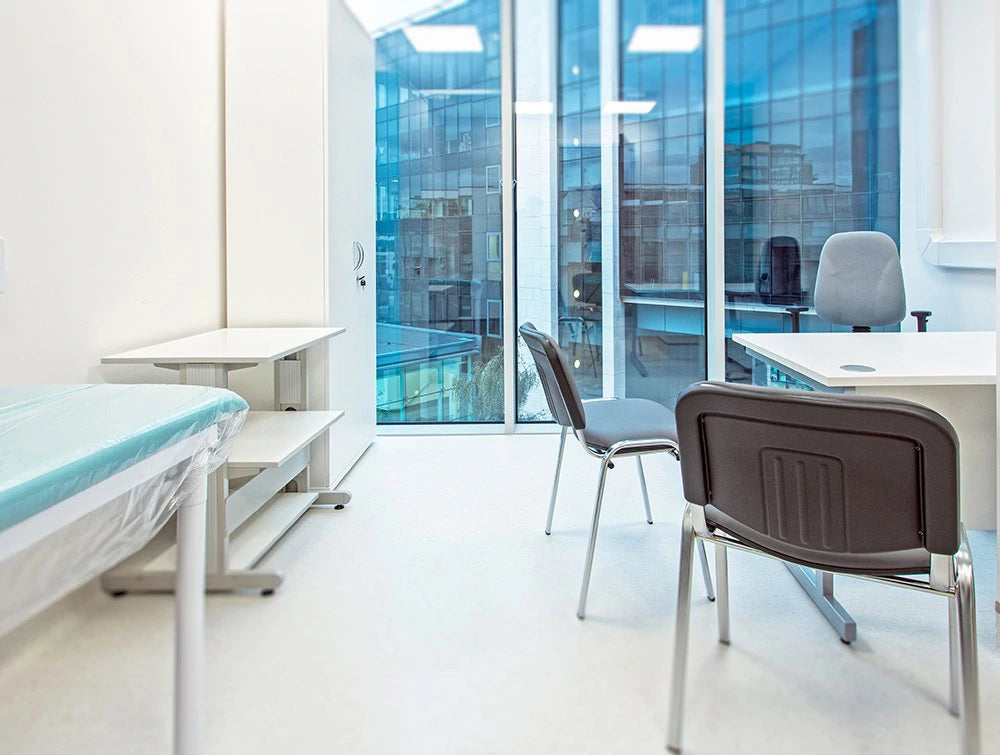 White Desk And Multiple Grey Chairs In Plain White Room